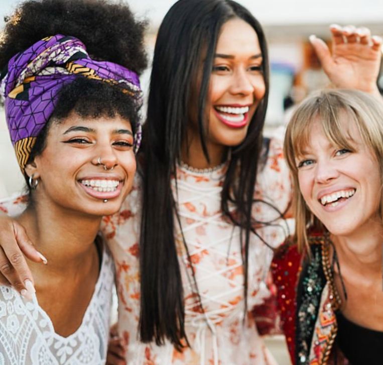 Women laughing joyfully outdoors in golden light
